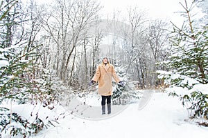 Young woman throwing snow in the air at sunny winter day, she is happy and fun.