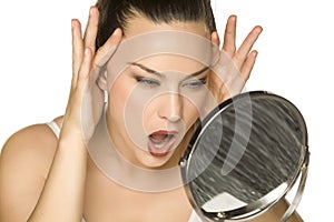 A young woman tightens her face with her hands