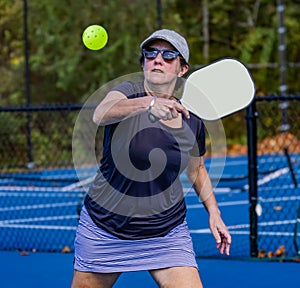 Young woman about to hit a backhand volley during pickleball