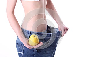 Young woman in too big pants with apple