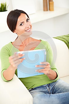 Young woman toothy smiling while holding a tablet