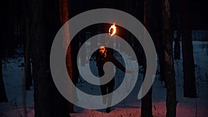 Young woman with torch running in the night forest