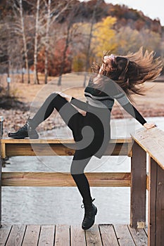 Young woman tossing her head back with long hair flying around her