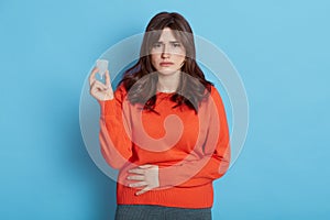 Young woman touches belly  holding flexible menstrual cup to insert in vagina during periods  protects from blood leakage