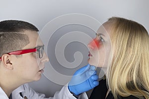 A young woman touches her nose, which is very painful. Medical care concept for difficulty breathing, clogged nasal passages and