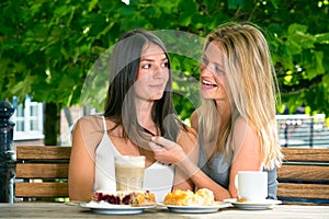 Young woman touching hair of her female friend