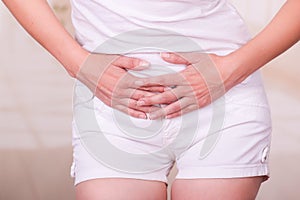 Young woman touching her belly, suffering menstrual period pain, female health concept