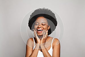 Young woman touching her face on white background. Pretty model having fun and laughing