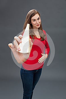 Young woman touching her hungry stomach, showing appetizing cheese