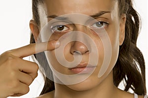 Young woman touching her low eyelids photo