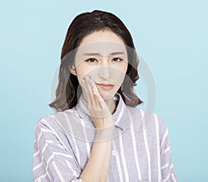 Young woman touching mouth with hand with painful expression