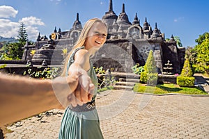 Young woman tourist in budhist temple Brahma Vihara Arama Banjar Bali, Indonesia Follow me concept