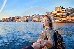 Young woman tourist enjoying beautiful landscape view on the old town Ribeira historical quarter and river Duoro during the