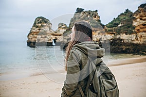 A young woman tourist enjoys beautiful views of the Atlantic Ocean and the landscape.