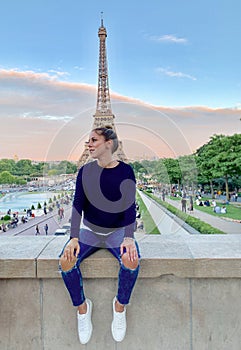 A young woman tourist in front of the Eiffel Tower, Paris, France