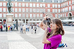 Young woman tourist holding a photo camera