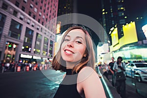 Young woman tourist laughing and taking selfie photo in New York City, Manhattan, Times Square