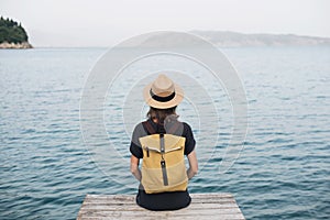 Young woman tourist looking at the sea. Traveler lifestyle, travel, enjoy life, summer holidays, vacations, mindfulness concept