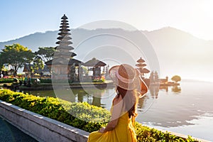 Young woman tourist relaxing and enjoying the beautiful view at Ulun Danu Beratan temple in Bali