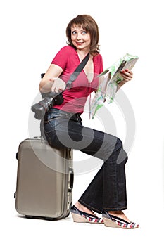 Young woman tourist sitiing on the suitcase
