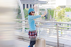 Young woman tourist with suitcases take a selfie