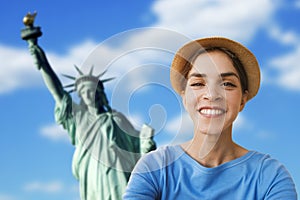 A young woman tourist is taking a selfie picture in front of the statue of liberty, in New York, United States of America