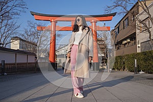 Young woman tourist travel Kyoto, Japan at Fushimi Inari Shrine main gate at sunrise