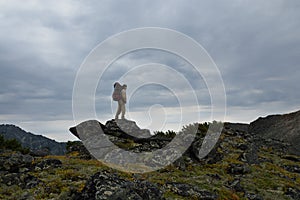 Young woman tourist walking on top of the mountain ridge Barguzinsky