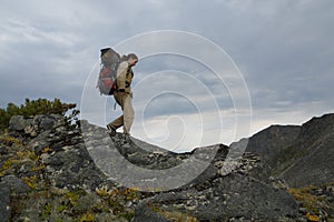 Young woman tourist walking on top of the mountain ridge Barguzinsky