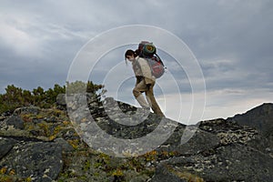 Young woman tourist walking on top of the mountain ridge Barguzinsky