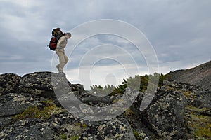 Young woman tourist walking on top of the mountain ridge Barguzinsky