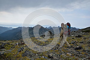 Young woman tourist walking on top of the mountain ridge Barguzinsky