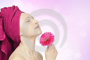 Young woman with towel and gerbera flower