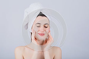 Young Woman With Towel On Head Smiling and enjoying a refreshing feeling after bathing. Body Care Concept. Young girl drying hair