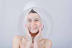 Young Woman With Towel On Head Smiling to Camera. Body Care Concept. Young girl drying hair with towel on head after shower