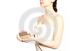 Young woman with a towel holding soap isolated on white background