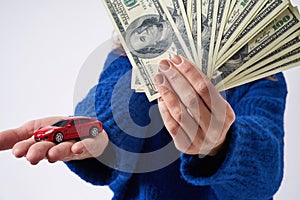 Young woman with a toy car and money in hand