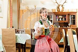 Young woman in traditional Bavarian Tracht in restaurant or pub