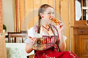 Young woman in traditional Bavarian Tracht in restaurant or pub