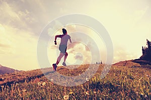 Young woman trail runner running on beautiful mountain peak