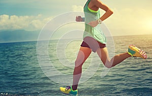 young woman trail runner running on seaside