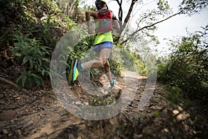 Woman trail runner running on tropical forest trai