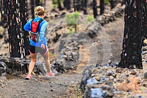 Young woman trail running in forest