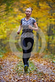 Young woman trail running in the forest