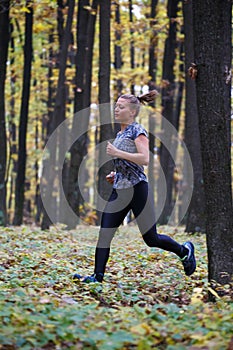 Young woman trail running in the forest