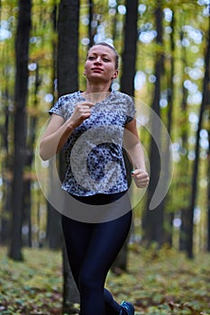 Young woman trail running in the forest