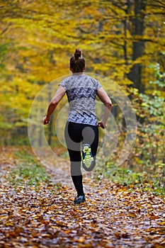 Young woman trail running in the forest