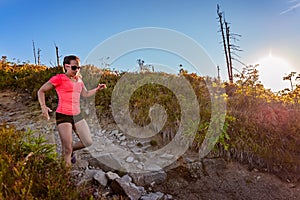 Young woman trail running in mountains at summer