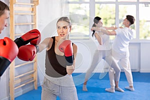 Young woman training in boxing fight in studio