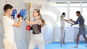 Young woman training in boxing fight in studio